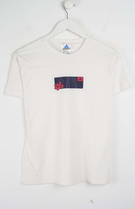 White t-shirt with a colorful patch on a hanger against a white background