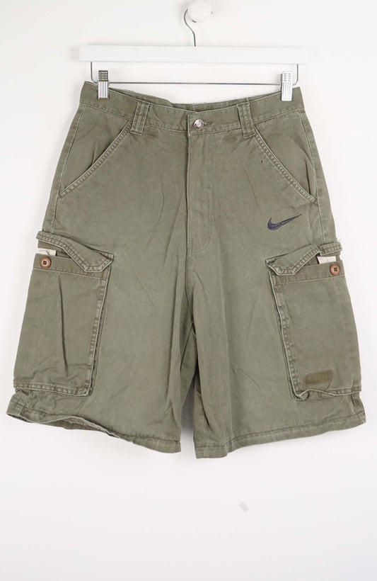 Green cargo shorts with a Nike logo on a white background